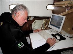 Urchin fisherman, Peter Halmay, entering population data into computer aboard his boat